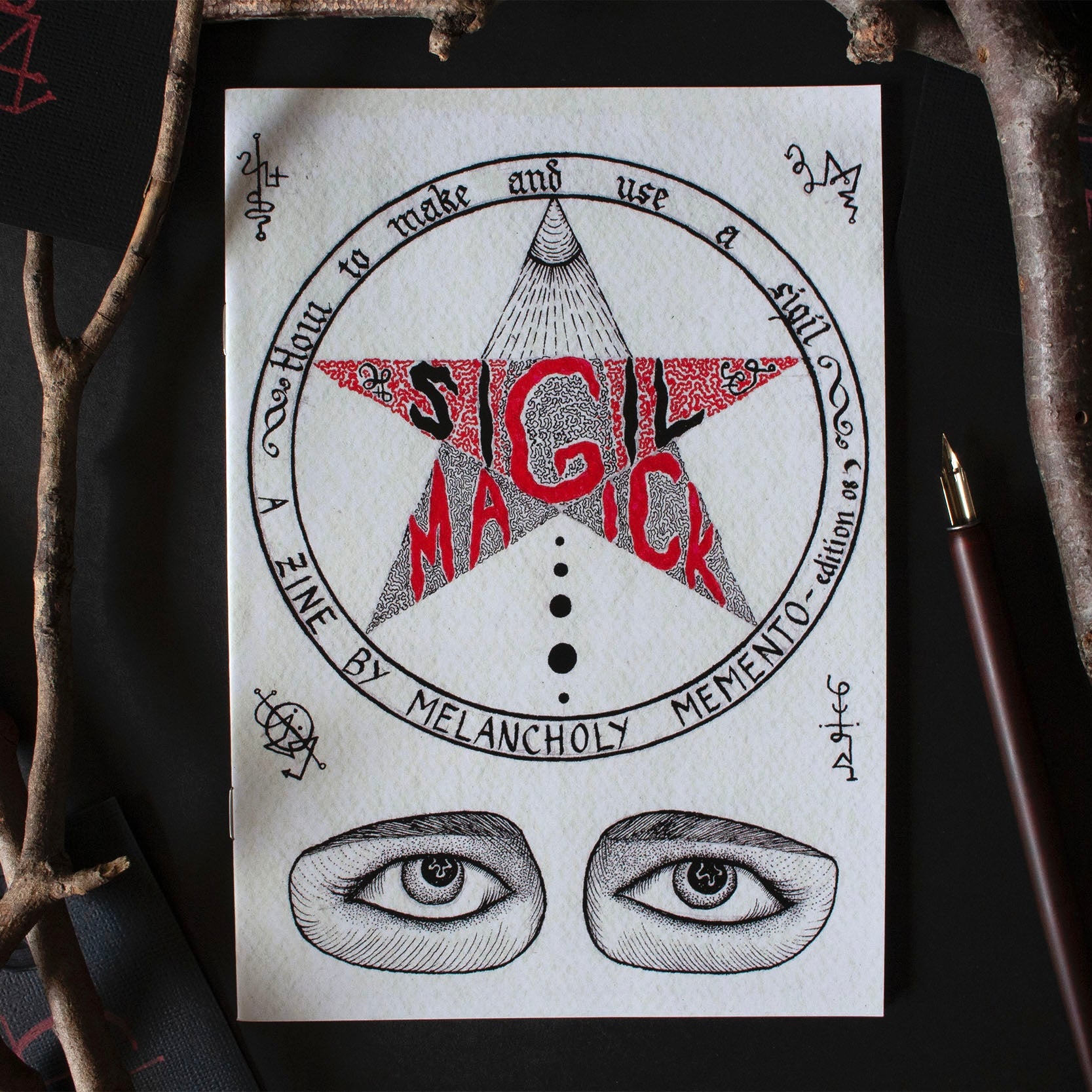 A5 sized zine titled 'SIGIL MAGICK' with a graphical design featuring a star eyes and stmbols. written and illustrated by Melancholy Memento.